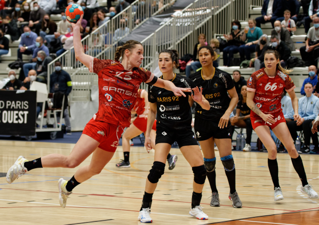 Eine Gruppe von Frauen spielt Handball auf einem Feld während der Handball-Weltmeisterschaft 2019 in Paris, mit Zuschauern im Hintergrund.