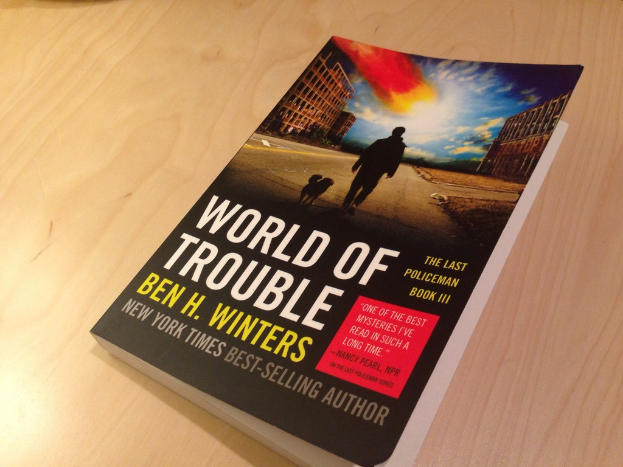 Ein Buch mit dem Titel "Welt der Probleme", das ein Bild von einem Mann und einem Hund zeigt, das auf einem Tisch liegt.