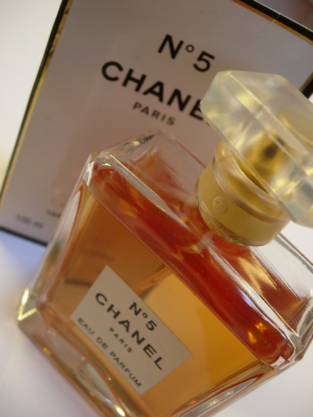 Eine Parfümflasche mit Etikett vor einem Rahmen mit Text.