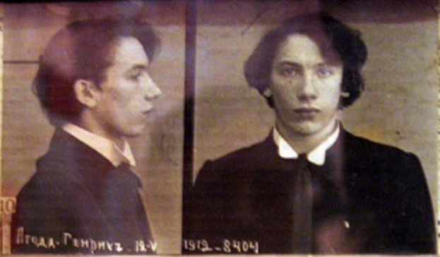Ein Mugshot eines Mannes in einem schwarzen Anzug, weißem Hemd und schwarzer Krawatte mit ernster Miene, gefalteten Händen und zurückgekämmtem Haar, begleitet von zwei kleineren Bildern von ihm und fettgedrucktem Text über seine Verbrechen.