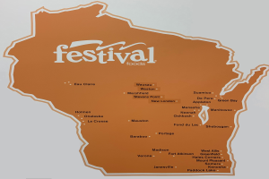 Ein lebendiger Plakatentwurf mit einer Wisconsin-Landkarte voller verschiedener Früchte, Gemüse und Snacks, auf dem 'Festival Foods' gedruckt ist.