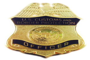 Goldene Plakette mit der Aufschrift "U.S. Customs and Border Protection Officer" vor einem weißen Hintergrund.