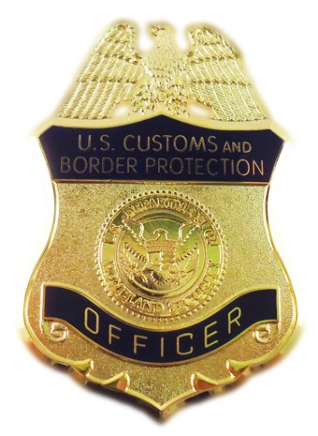 Goldene Plakette mit der Aufschrift "U.S. Customs and Border Protection Officer" vor einem weißen Hintergrund.