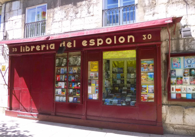 Ein zweistöckiges Gebäude mit einer roten Markise und einem Ladenschild, das "Libreria del Espolon" lautet.
