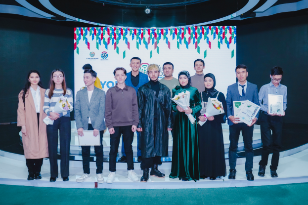 Eine Gruppe von Menschen auf einer Bühne mit Blumensträußen und Urkunden, im Hintergrund ein Schild mit der Aufschrift "Jugend-Solar-Awards 2019".