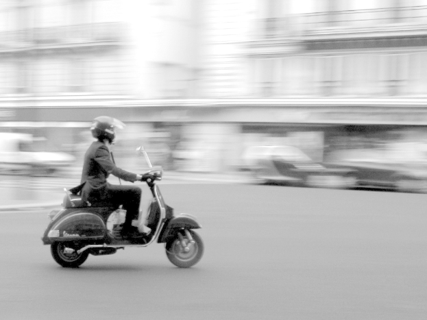 Eine Person, die ein Scooter auf einer Stra√üe f√§hrt.