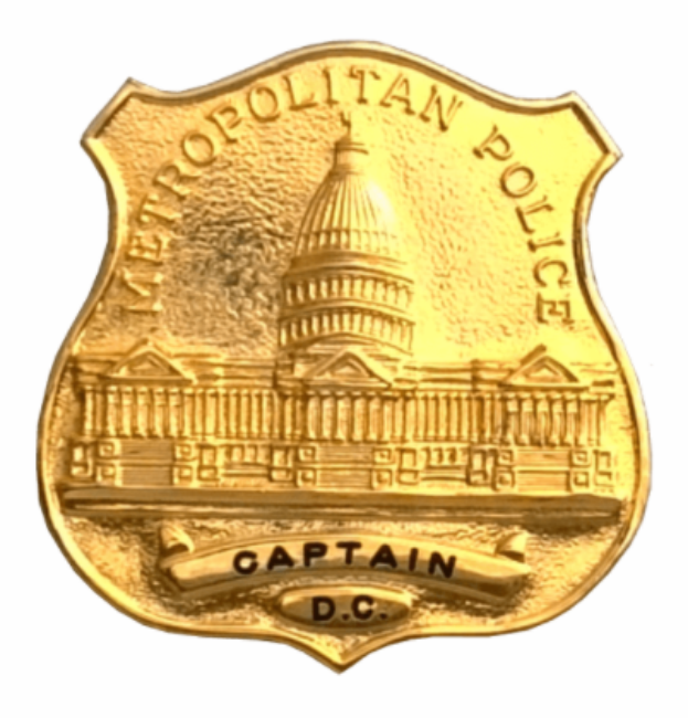 Ein goldenes Polizeibadgebnis mit der Inschrift "Metropolitan Police Captain" auf einem weißen Hintergrund.