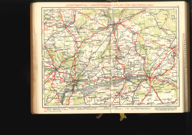 Offenes Buch mit einem detaillierten Kartenausschnitt von Deutschlands Straßen und Autobahnen auf einem schwarzen Hintergrund.