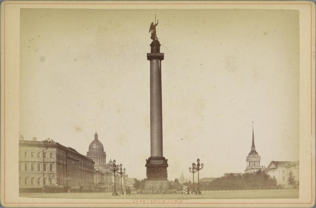 Altes Schwarz-Weiß-Foto eines Denkmals in einem städtischen Platz mit umgebenen Gebäuden, Straßenmöbeln, Bäumen und einem klaren Himmel, mit Text unten.