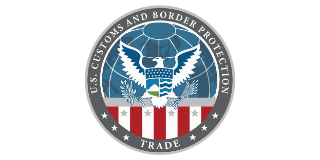 Logo der U.S. Zoll- und Grenzschutzbehörde Handel: ein blauer Kreis mit einem weißen Stern, der eine weiße Taube mit ausgebreiteten Flügeln enthält, und der Text "U.S." darüber.