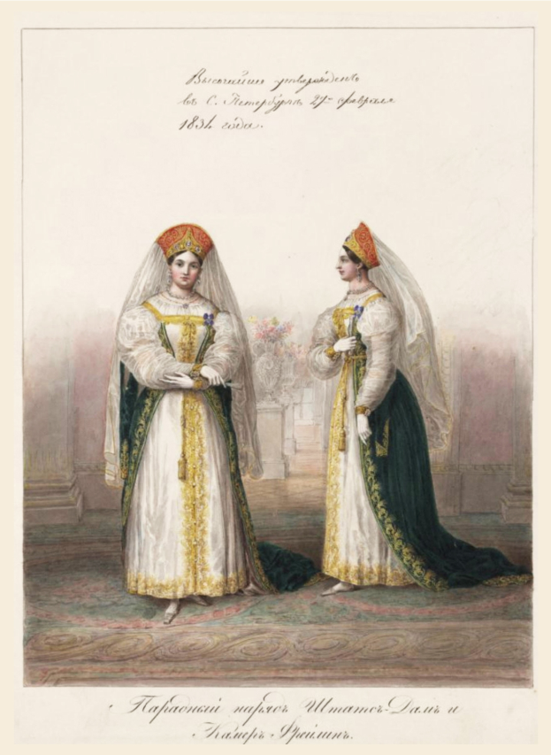 Zwei Frauen in traditionellen russischen Hochzeitskleidern, die mit kunstvoller Stickerei und Perlen verziert sind, stehen auf einem Teppichboden, lächeln und sehen sich an, wobei eine einen Blumenstrauß hält.