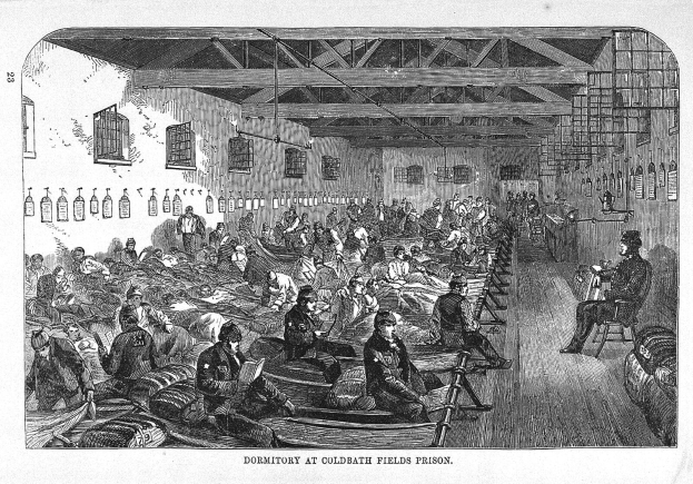 Schwarze und weiße Zeichnung eines überfüllten Gefängnis-Schlafsaals mit Menschen, die auf Fässern und verstreuten Gegenständen sitzen oder stehen, beschriftet mit "Schlafsaal auf dem Coldwater Fields Prison" unten.