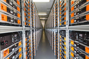 Eine lange Reihe von Servern in einem Rechenzentrum mit elektronischen Geräten in den Racks und Lampen oben.