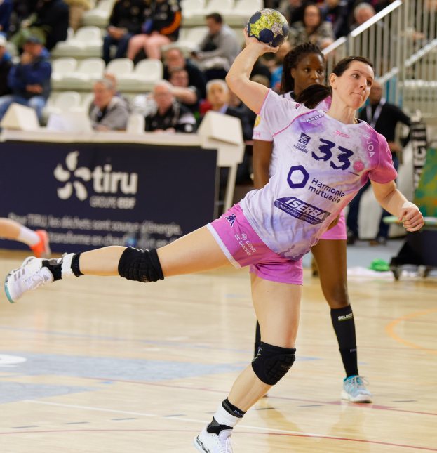 Eine Gruppe von Frauen spielt Handball auf einem Feld mit einem Ball in der Mitte, in einem Stadion mit Zuschauern und einer Tafel mit der Aufschrift "Futsal-Weltmeisterschaft 2019, Paris, Frankreich".