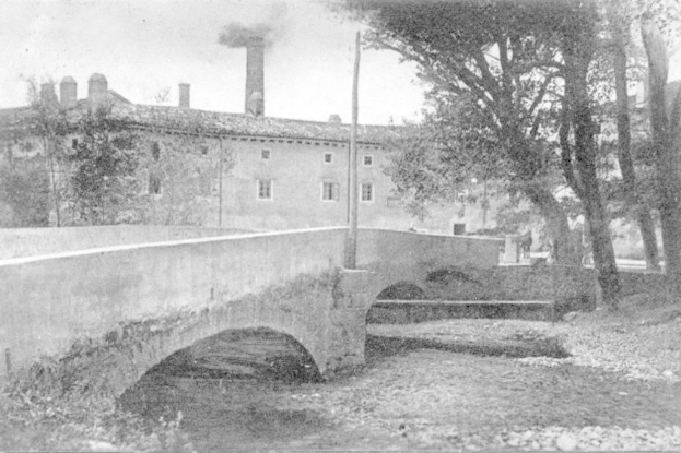 Eine Szene mit Gebäuden und Bäumen, einem Pfahl und einer Brücke im Vordergrund, Himmel oben, Wasser unten und Rauch, der aus einem Schornstein aufsteigt.