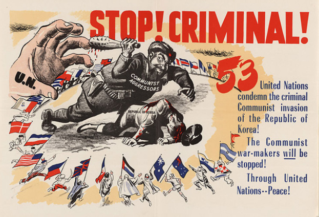 Eine Hand hält ein Schild mit der Aufschrift "Stoppen Sie den Verbrecher" mit einer Gruppe von Menschen im Hintergrund, die Fahnen halten, und Text auf dem Plakat, der die Verwendung von menschlichem Haar befürwortet.