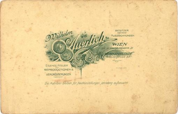 Ein altes deutsches Geldstück mit einem Porträt eines Mannes in Anzug und Krawatte mit ernster Miene, mit der Aufschrift "Wilhelm Auerlich Wien" darauf.